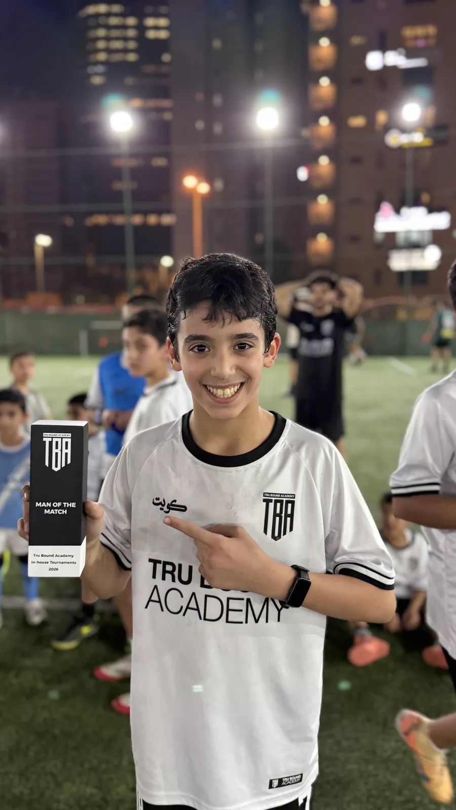 Young academy player smiling with a presentation box