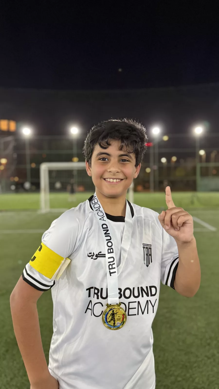 Academy player wearing a medal and giving a thumbs up